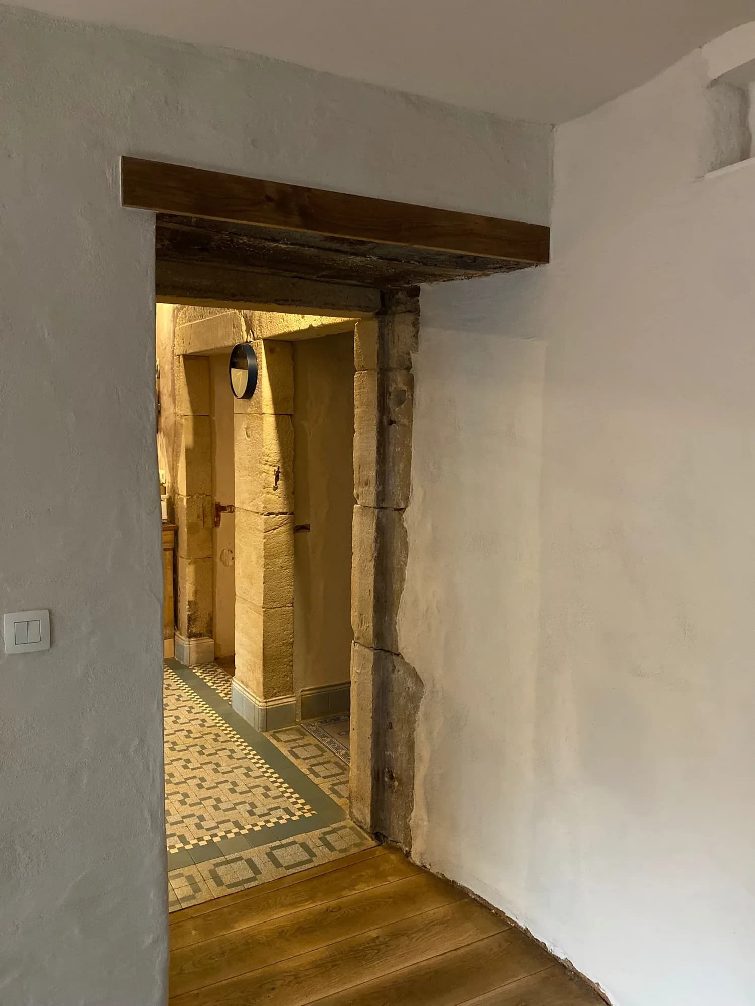 Passage voûté d'une bâtisse ancienne entièrement enduit à la chaux, sol en carreaux de ciment