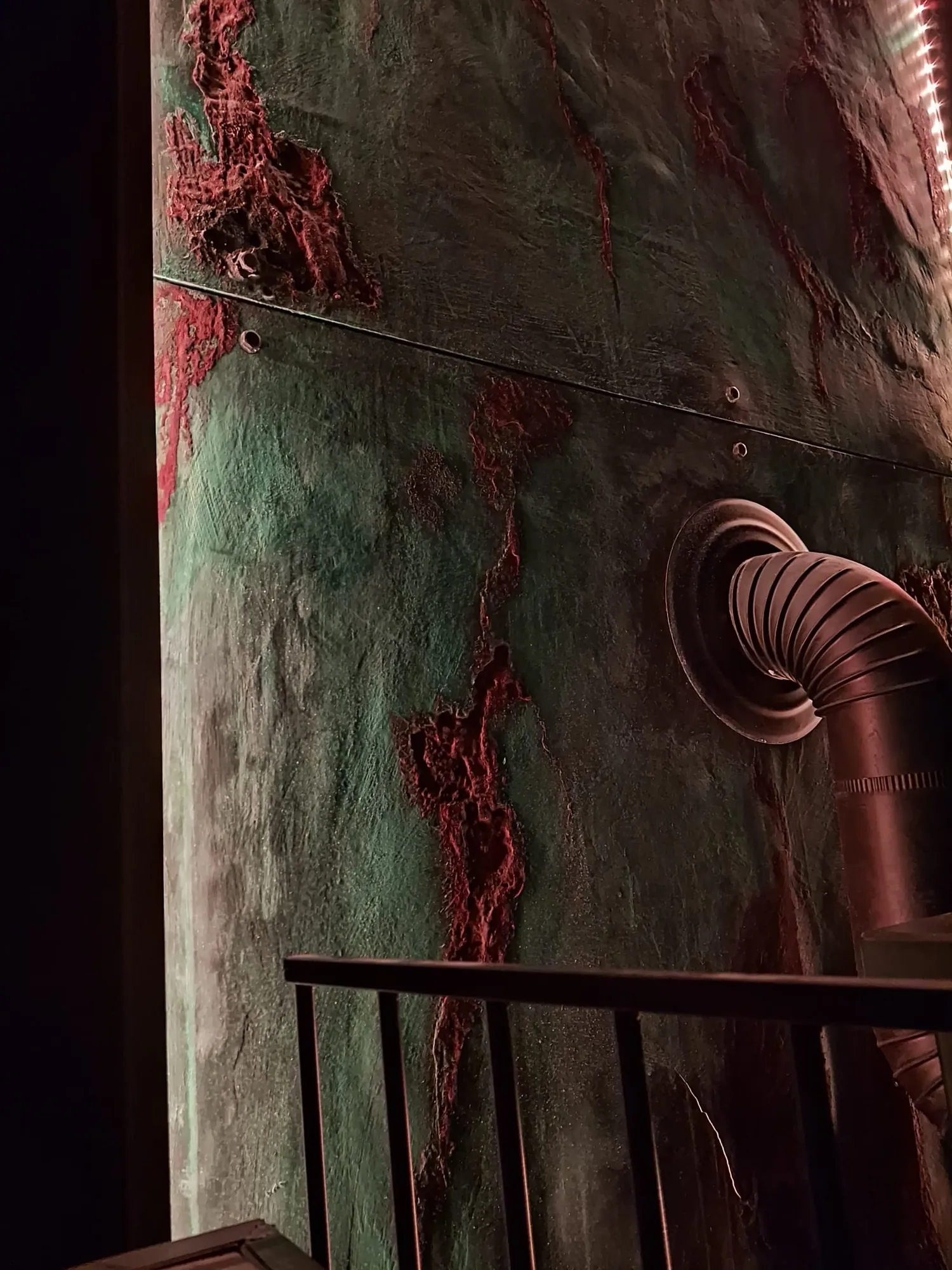 Mur décoratif à effet métal oxydé le long d'un escalier, nuances rouille et vert-de-gris